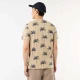 Remera de manga corta color beige con estampado integral de palmeras en azul marino, cuello redondo y corte clásico.