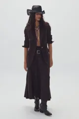 Falda midi de gamuza color marrón, con diseño de corte amplio, tajo lateral y cintura con elástico en la parte trasera. Cuenta con cierre metálico lateral y forro interior.