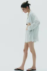 Short de algodón con estampado de rayas verticales finas en tonos verde menta y blanco. Presenta cintura elástica y corte holgado.