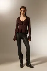 Calza de tiro medio confeccionada en cuero sintético negro, con diseño ajustado al cuerpo.