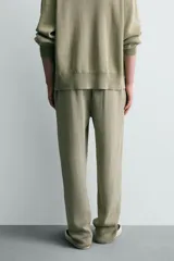 Pantalón relaxed fit tejido en hilatura de algodón con estructura, color verde militar. Presenta cintura elástica ajustable con cordón en contraste, bolsillos de vivo frontales y detalle de bolsillo trasero.