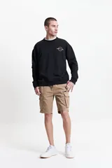 Buzo de felpa negro para hombre, con escote redondo, puños y lettering y logo estampado en la espalda con la frase 'Premium Creative Studio'.