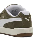 Championes Puma modelo Park Lifestyle Easy, color verde oliva con detalles en blanco. Confeccionados en gamuza, cuentan con la icónica franja lateral de la marca, suela de goma en tono crema y base marrón.