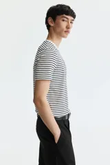 Remera de algodón liviano con diseño de rayas horizontales en blanco y negro, cuello redondo ribeteado y corte ajustado.