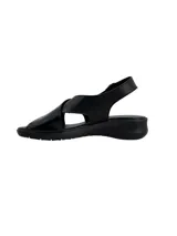 Sandalias negras con tiras cruzadas en el empeine, talón cubierto y tira con hebilla ajustable. Cuenta con suela baja y cómoda.