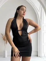 Minivestido negro con escote halter y abertura en el abdomen.