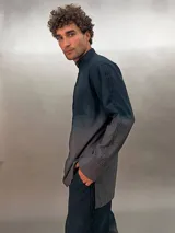 Camisa de lana color gris con cuello mao, corte recto y mangas largas con detalle texturizado. Presenta cierre invisible en el escote superior y tajos laterales.