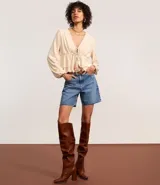 Blusa color crema con escote en V, mangas largas y lazo en el busto.