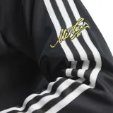 Campera deportiva Adidas de la colección Juventus Originals, con cierre frontal, cuello alto y puños acanalados. Presenta diseño en color negro con detalles en blanco en cuello, puños y ruedo, además de las icónicas tres tiras en las mangas. Incluye logo de Adidas Trefoil y escudo del club en el pecho.