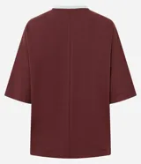 Remera de corte boxy color bordó, con cuello en V en color menta, mangas cortas con recortes y estampa frontal con temática deportiva en color menta.