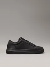 Zapatillas urbanas de cuero granulado color negro, con suela cupsole gruesa, interior de espuma, forro de malla de poliéster y logo de Calvin Klein en la lengüeta y el talón.