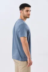 Remera gris de manga corta con cuello redondo y estampa frontal de paisaje costero con tablas de surf y la leyenda "Having Fun".