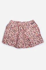 Short de baño celeste con estampado de hojas pequeñas en tonos verdes y blancos. Cuenta con cintura elástica con cordón ajustable, bolsillos laterales y un parche circular con logo en la parte inferior.
