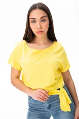 Remera amarilla de algodón y elastano, con escote redondo y mangas cortas. Presenta un nudo lateral en la cintura.