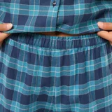 Conjunto de pijama largo de dos piezas, compuesto por camisa de manga larga con cuello y pantalón de corte recto. Diseño a cuadros en tonos azul y verde.