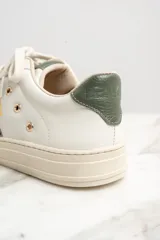 Zapatillas urbanas de cuero color blanco con detalles en verde.