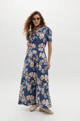 Pantalón de lino azul con estampado floral en tonos rosados y blancos, de tiro medio-alto, con tablas delanteras, bolsillos laterales y corte amplio.