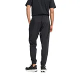 Pantalón deportivo New Balance de corte jogger, color negro, con cintura elástica ajustable mediante cordón, puños elásticos en los tobillos y logo de la marca bordado en la pierna izquierda.