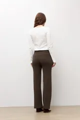 Pantalón tejido marrón oscuro de corte recto, con cintura elástica y cordón ajustable.