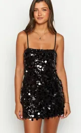Vestido corto negro con lentejuelas, breteles finos y corte ajustado.