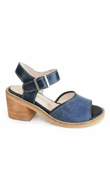 Sandalias de cuero combinadas en azul y negro, con diseño de textura croco en la capellada, costuras en contraste y taco ancho de madera. Poseen tira al tobillo con hebilla metálica regulable.