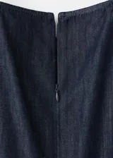 Mono largo de denim color azul oscuro, con escote halter y diseño recto en las piernas.