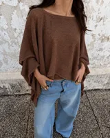Poncho tejido de punto color marrón, con escote bote y mangas amplias.