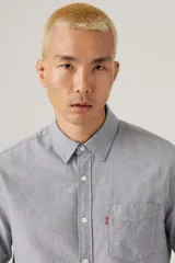 Camisa de hombre Levi's de manga larga, color gris jaspeado, con cuello clásico, cierre frontal con botones, bolsillo en el pecho y logo de la marca en etiqueta roja.
