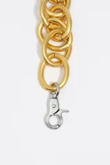 Collar maxi de cadena con eslabones circulares entrelazados de acabado plateado mate y cierre de mosquetón dorado.