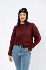 Sweater de punto color bordó con cuello redondo, mangas largas y calce relajado.