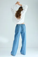 Pantalón de jean de corte holgado y pernera recta, color celeste con efecto deslavado. Cuenta con cintura elástica fruncida y cordón ajustable.