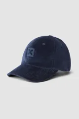 Gorro de béisbol de pana color azul marino, con visera curva y parche bordado con una 'X' en el frente.