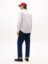 Camisa de popelín de puro algodón de corte regular, con diseño de rayas finas, cuello clásico, mangas largas con puños abotonados y el logo de la marca bordado en el pecho.
