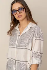 Camisa de manga larga de corte holgado, color blanco con estampado abstracto y floral en tonos ocre y azul.