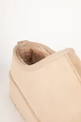 Zueco de gamuza color beige con interior forrado en piel sintética y plataforma de 5 cm de altura.