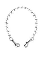 Cadena para pantalón de metal plateado con eslabones en forma de estrellas tridimensionales y cierres de mosquetón en ambos extremos.