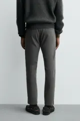 Pantalón chino de corte ajustado, color beige, con bolsillos laterales y bolsillos traseros de vivo. Cuenta con cierre frontal de cremallera y botón.