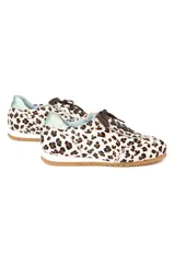 Zapatillas de estilo running con estampado animal print de leopardo sobre fondo blanco. Presentan detalles en piel verde tornasolada en la parte trasera y lengüeta, cordones oscuros y suela de goma dentada con cuña interna.