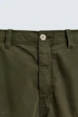 Bermuda cargo de corte relajado confeccionada en algodón, con bolsillos laterales tipo plastrón con solapa, bolsillos frontales y bajo ajustable con cordón.
