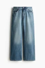 Jean de tiro alto y corte baggy, confeccionado en denim de algodón rígido en color celeste con efecto deslavado. Presenta diseño de cinco bolsillos, piernas rectas y holgadas, y cierre frontal con botón y cremallera.