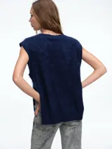 Chaleco tejido sin mangas con escote en V, confeccionado en cashmere con textura suave y diseño de líneas simples.
