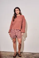 Sweater de tejido bouclé texturado color beige, con cuello redondo y mangas largas holgadas de corte amplio.