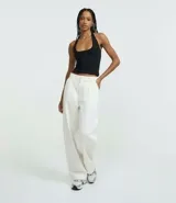 Blusa frente única de microfibra color beige, con escote cuadrado y breteles que se ajustan al cuello. Diseño sin mangas y espalda descubierta.