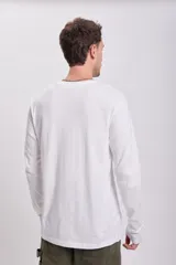Remera básica de manga larga blanca, cuello redondo y corte clásico.