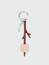 Llavero Longchamp de metal plateado con argolla grabada, dije colgante con la silueta de un galgo y un colgante en forma de rama de cuero marrón con un malvavisco de cuero beige.