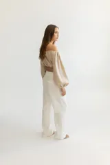 Blusa corta color salmón, con escote recto con elástico, mangas largas abullonadas con elástico en los puños y corte crop.