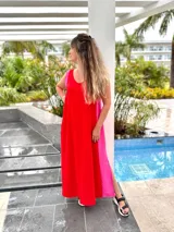 Vestido largo negro con panel lateral blanco, escote en V en la espalda y corte holgado.