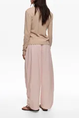 Pantalón jogger negro confeccionado en mezcla de lyocell y algodón, de tiro medio con bolsillos laterales y bajos ajustables mediante cordones elásticos con stoppers.