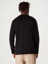 Remera marrón de manga larga, cuello redondo y diseño liso básico.