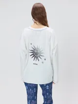 Remera oversize de manga larga color naranja con efecto gastado, cuello redondo y gráfico estampado en la espalda.